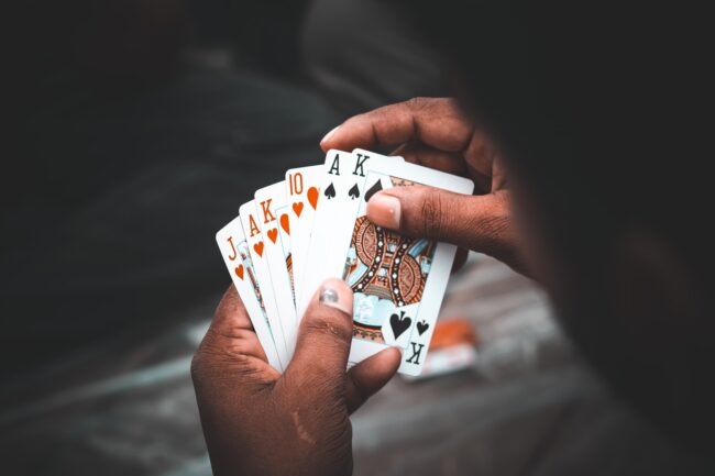 A man holding a handful of cards