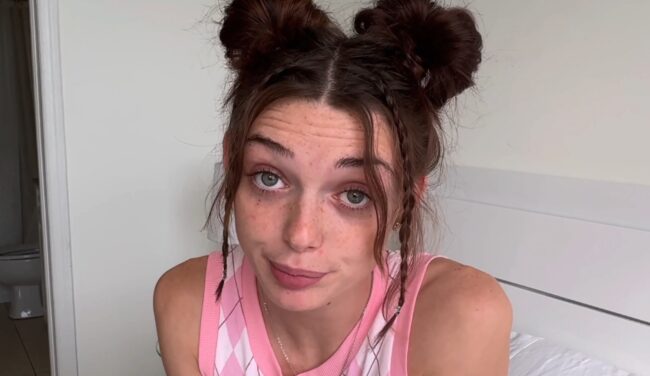 Person with space buns hairstyle looking at the camera indoors