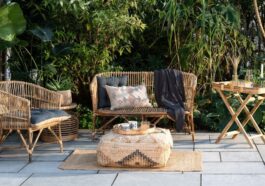 Cozy patio with wicker furniture, cushions, and a patterned pouf