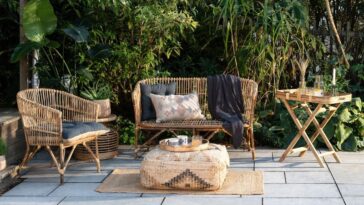 Cozy patio with wicker furniture, cushions, and a patterned pouf
