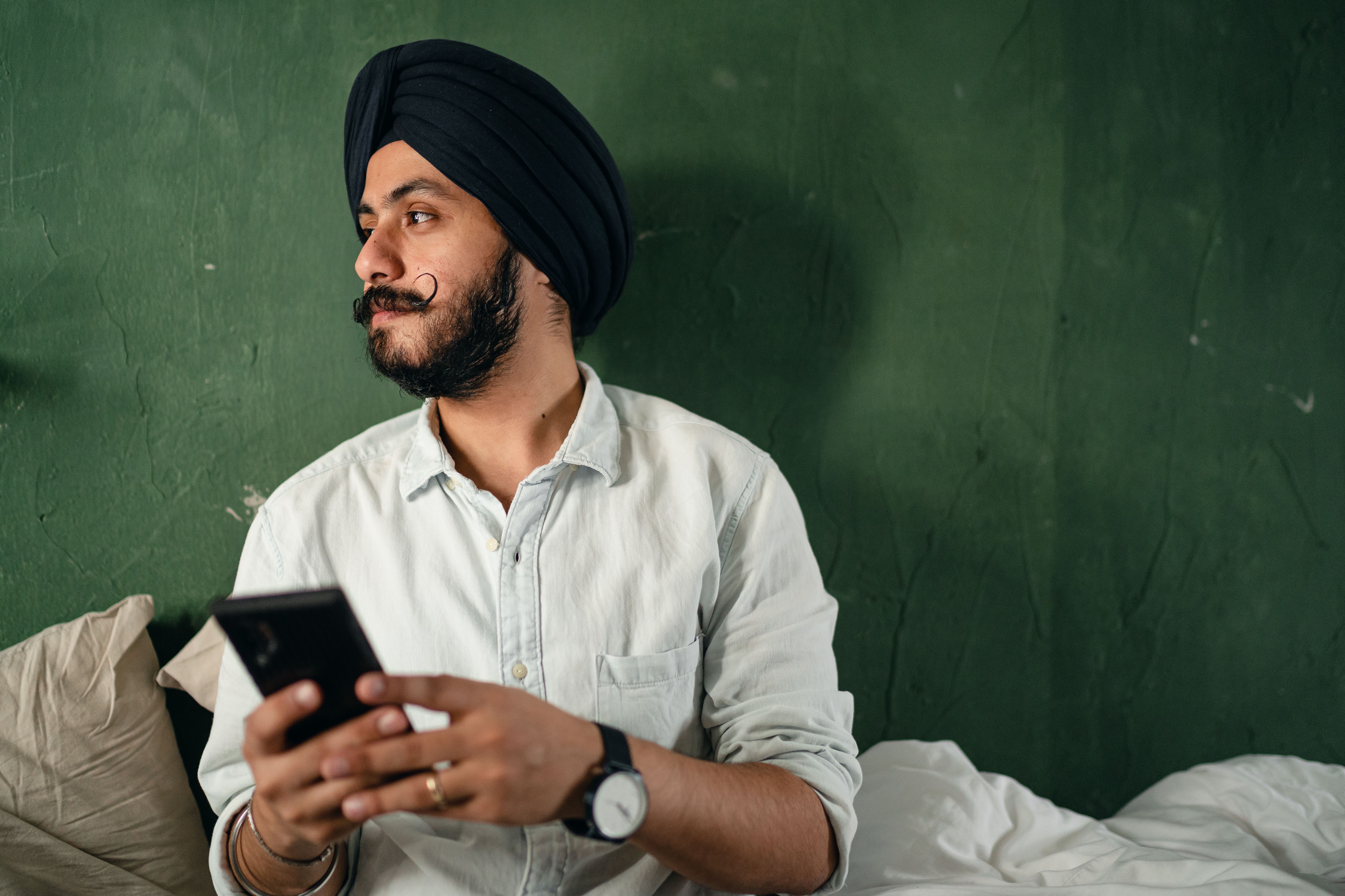 Indian man browsing a mobile gaming app on his smartphone at home