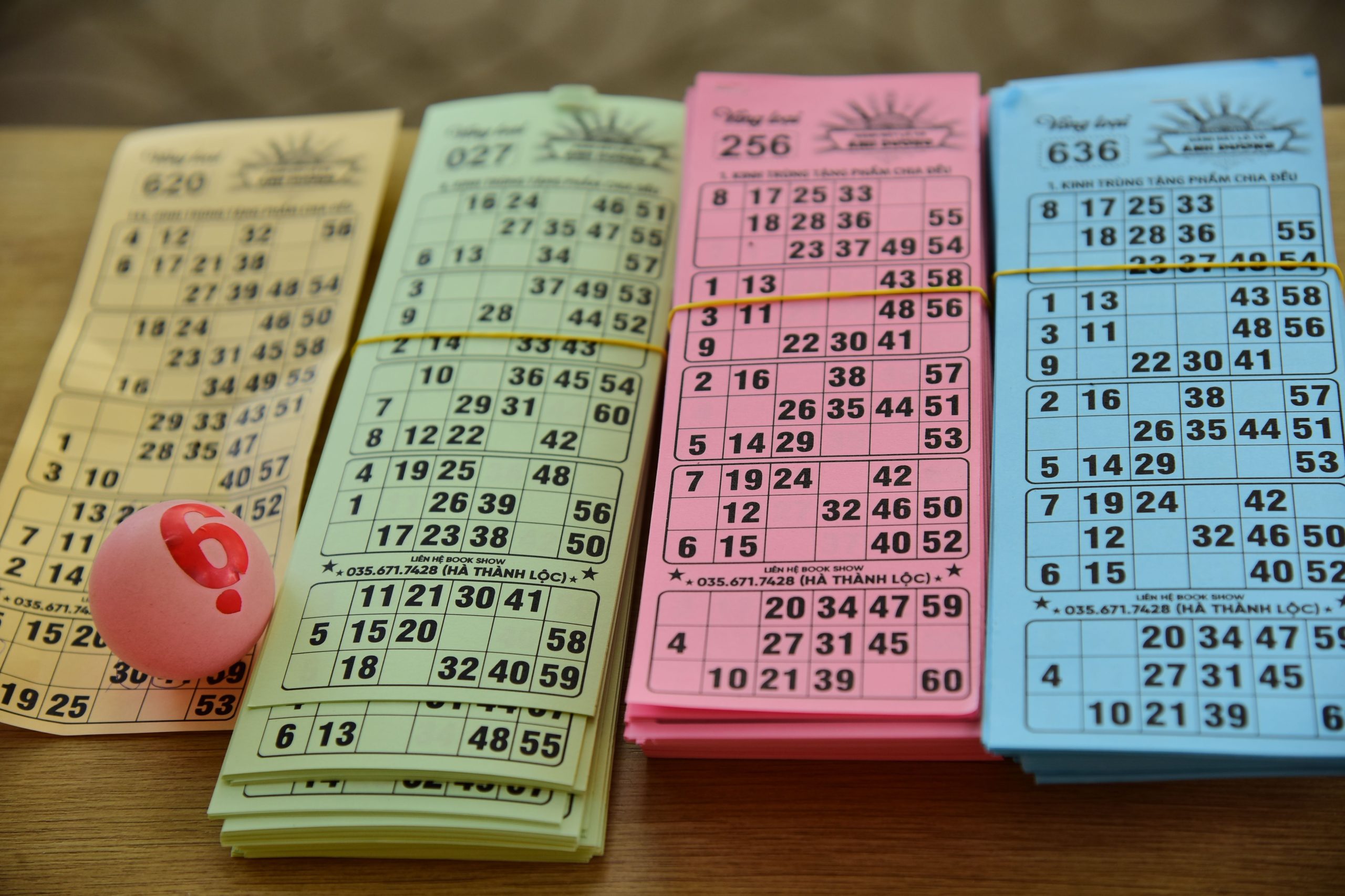 Colorful bingo cards and a numbered ball arranged on a table for a game night