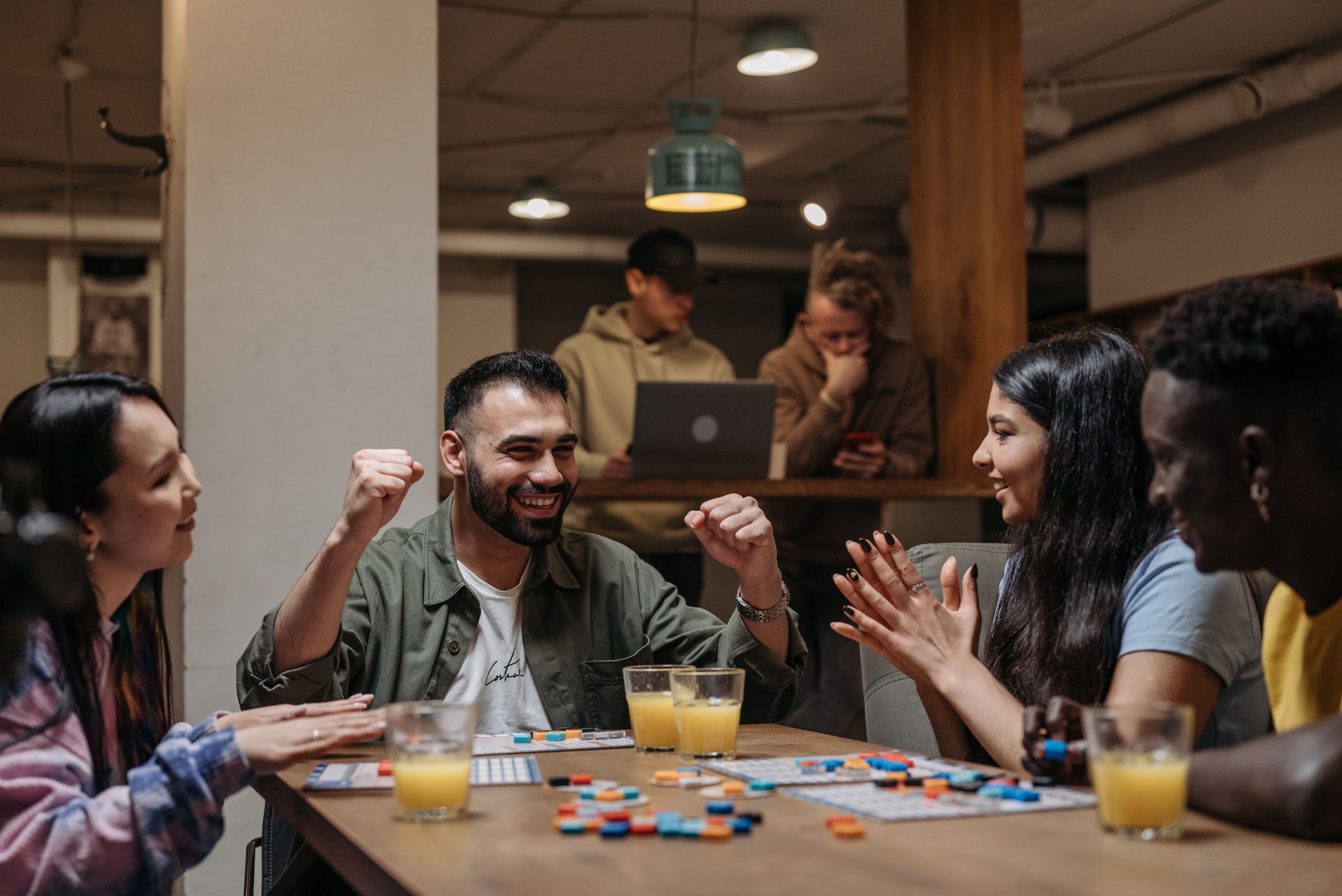Group of friends playing a board game indoors enjoying fun and laughter
