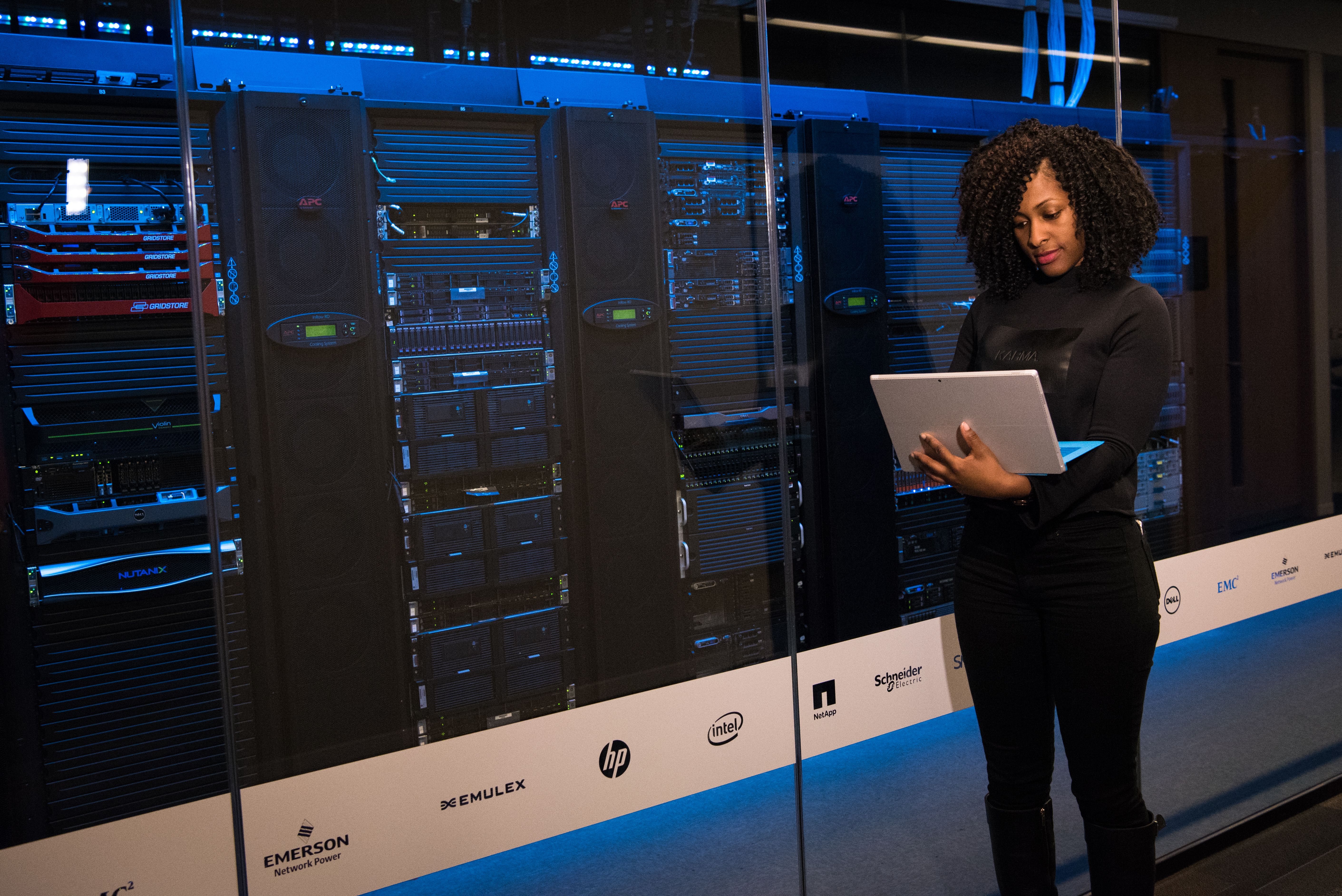 IT engineer using a laptop to monitor data servers in a modern server room