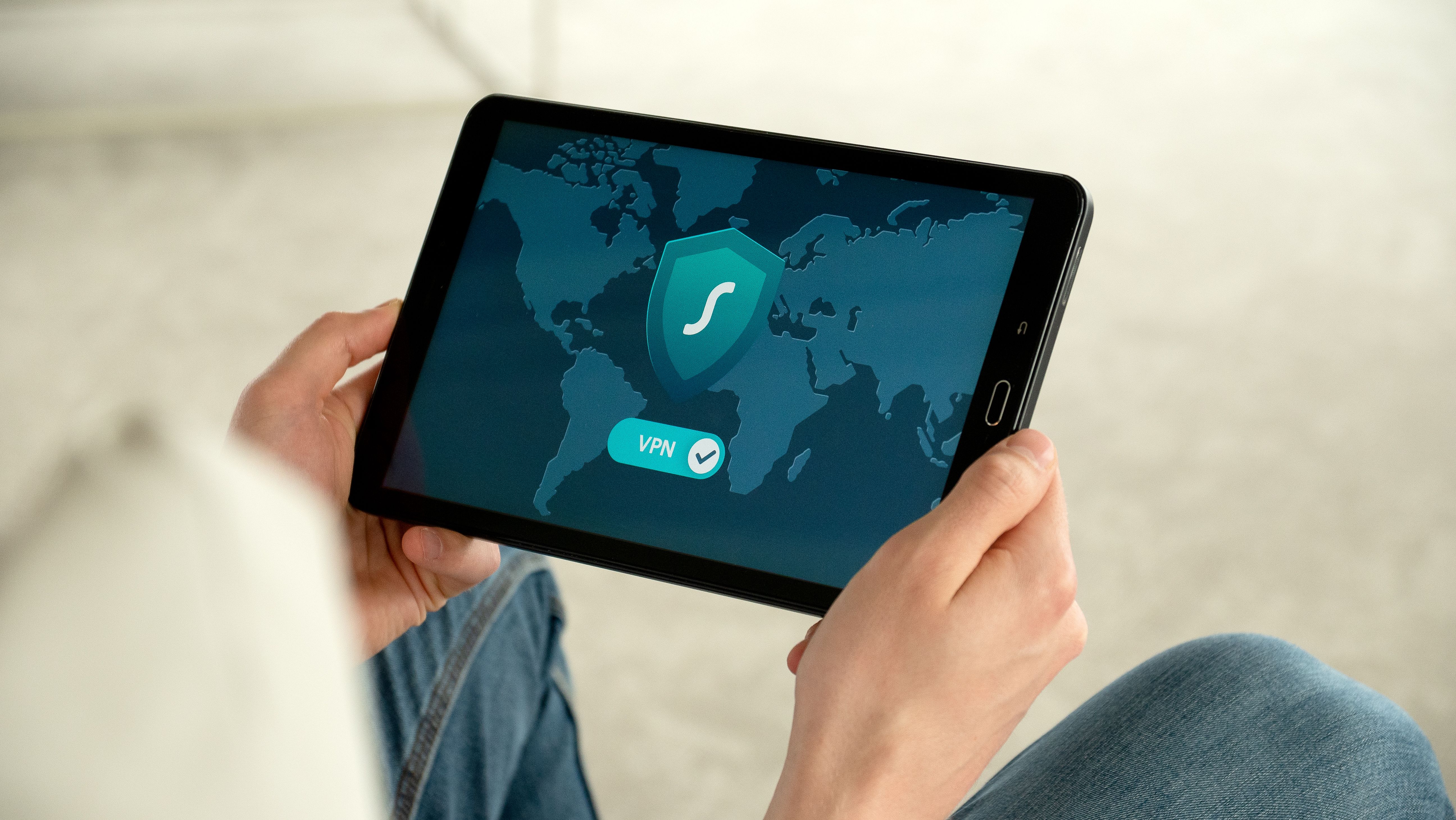 Person holding a tablet displaying a VPN connection screen for secure, private internet browsing