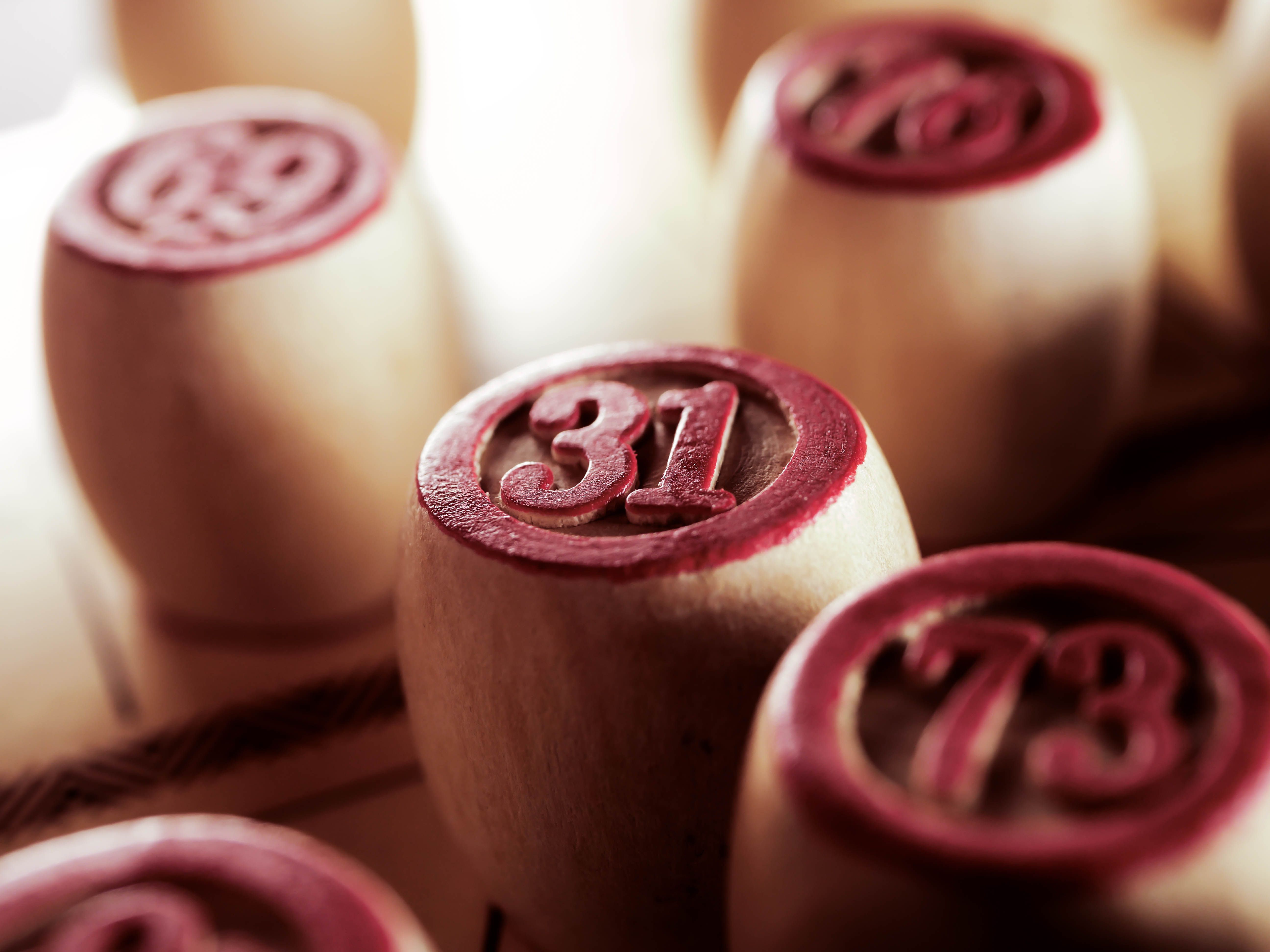 Wooden bingo game chips in focus displaying numbers 31 and 73