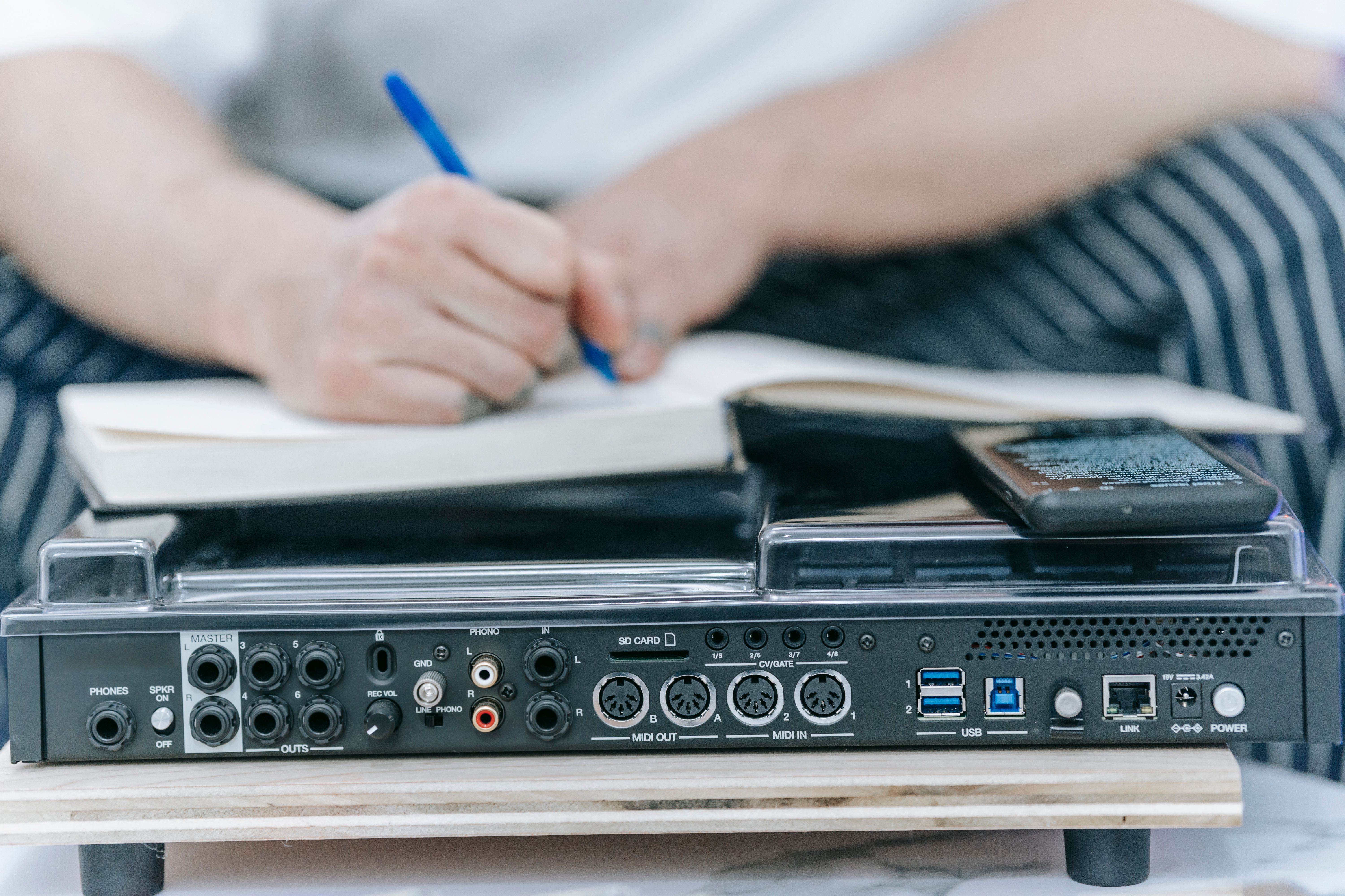 Close view of an audio mixing console with handwritten notes, suggesting a focused and organized production process.