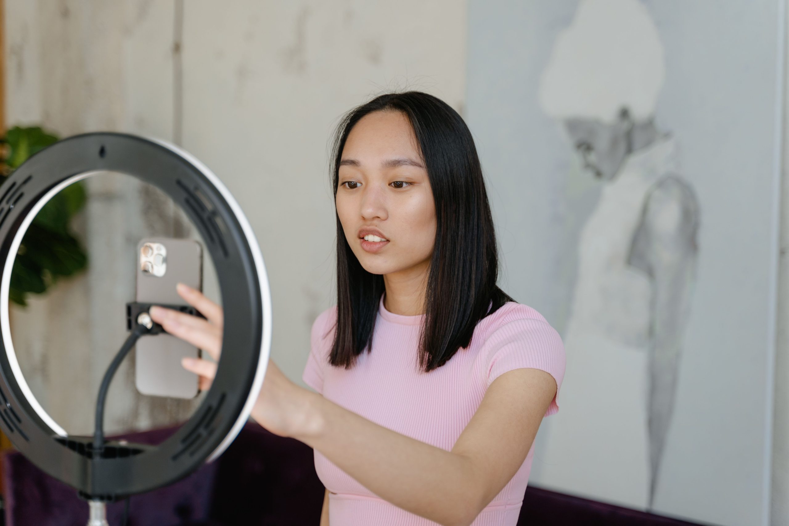 Instagram creator filming a polished smartphone video beside a ring light.