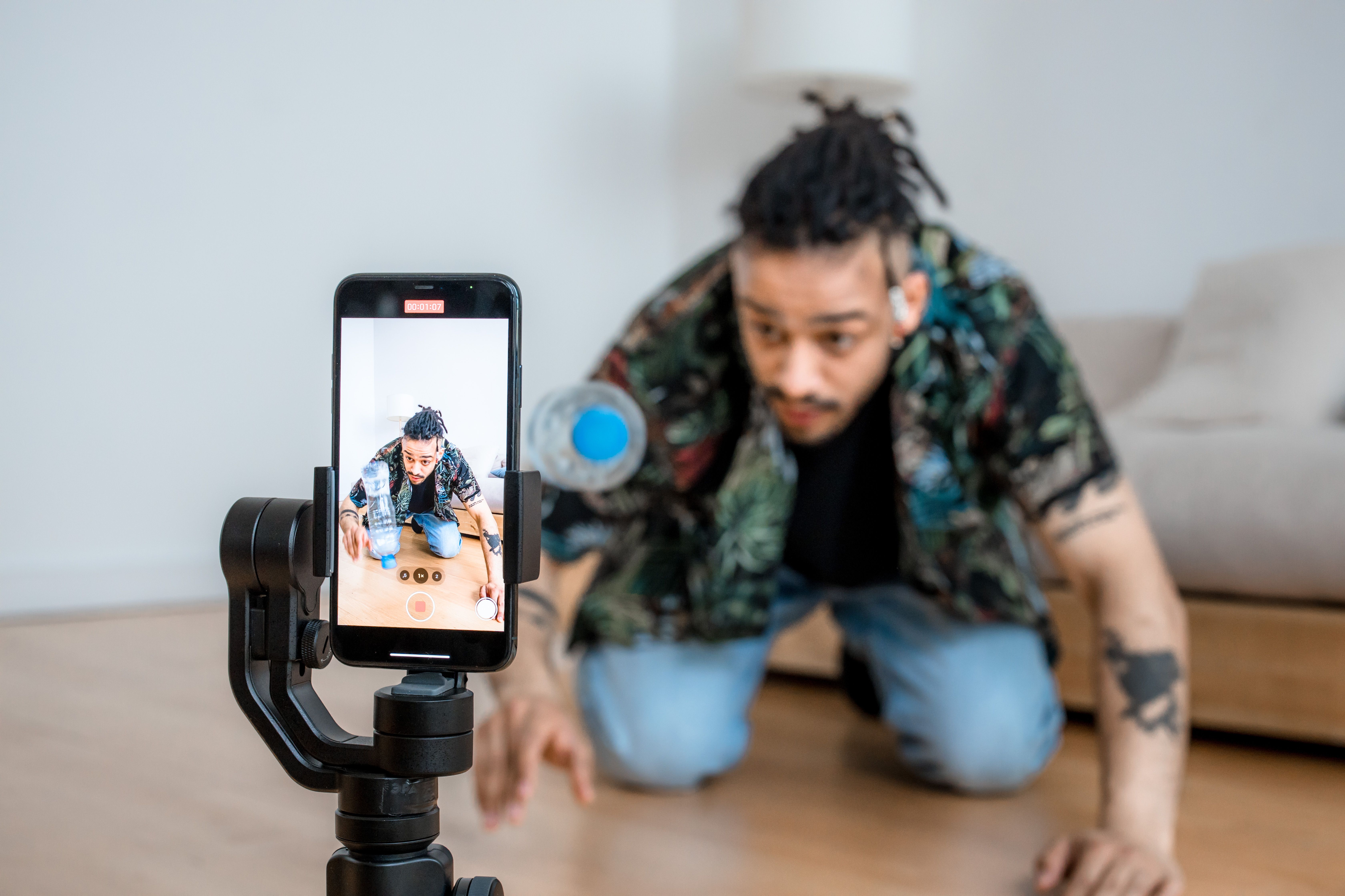 Creator recording a social media video with a smartphone mounted on a gimbal.