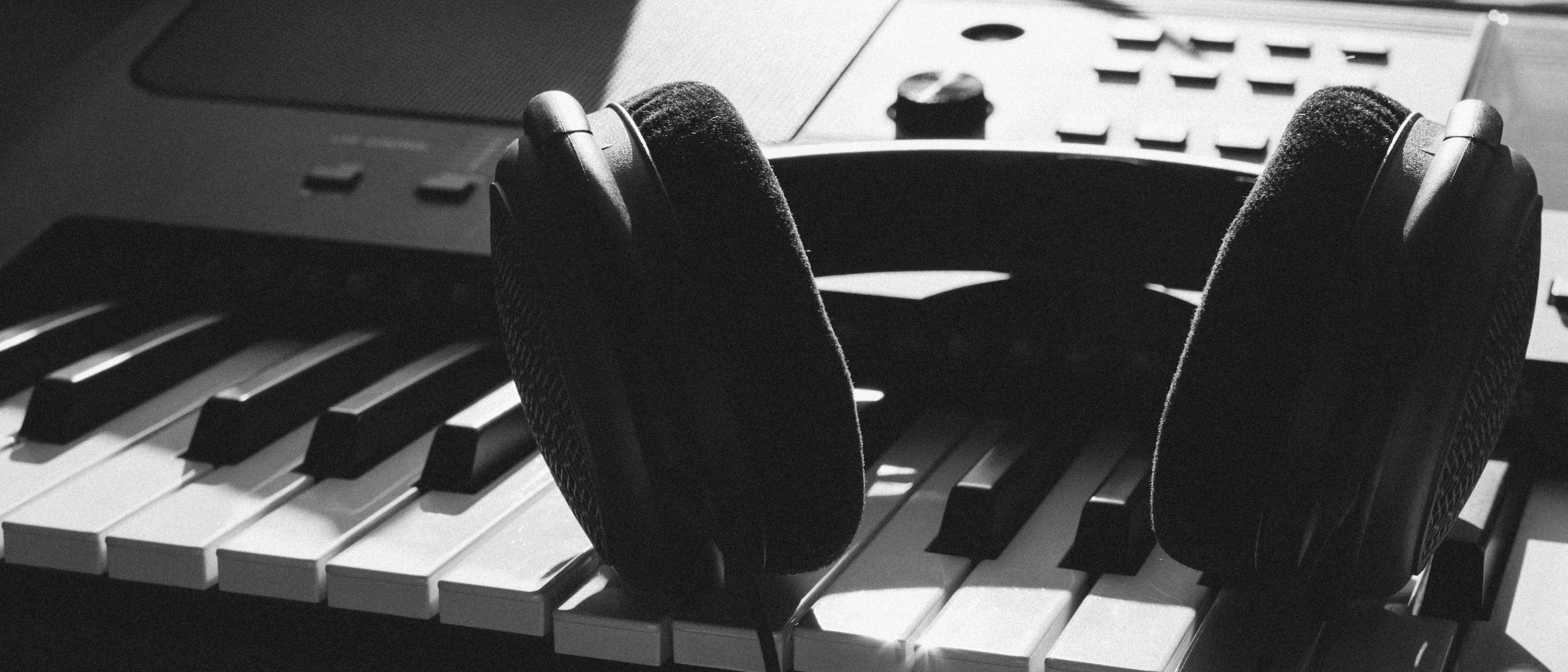 Headphones resting on piano keys, ready for a creative music production session.
