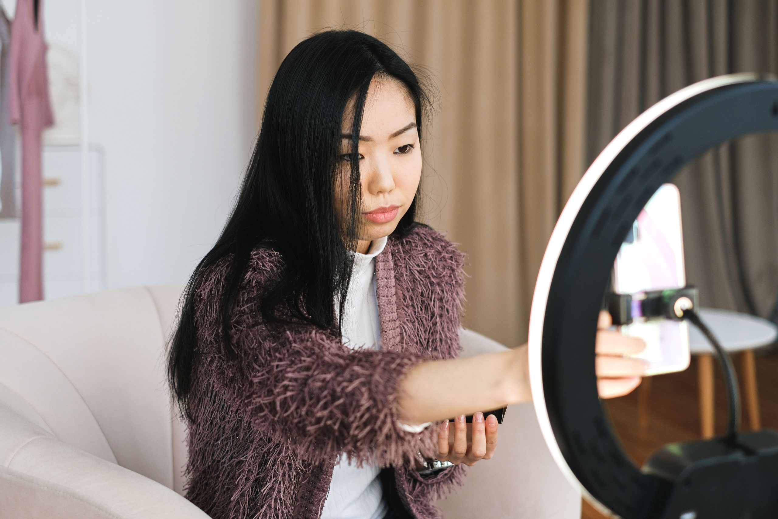 TikTok creator filming a short-form video at home with a smartphone and ring light